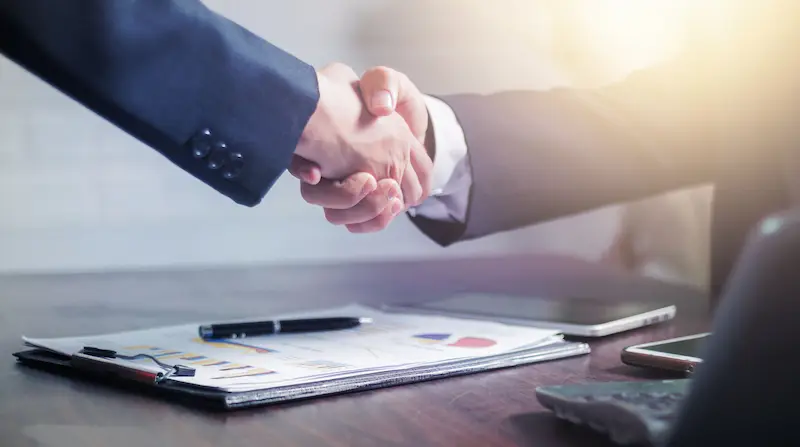 Business handshake representing real estate and infrastructure partnerships